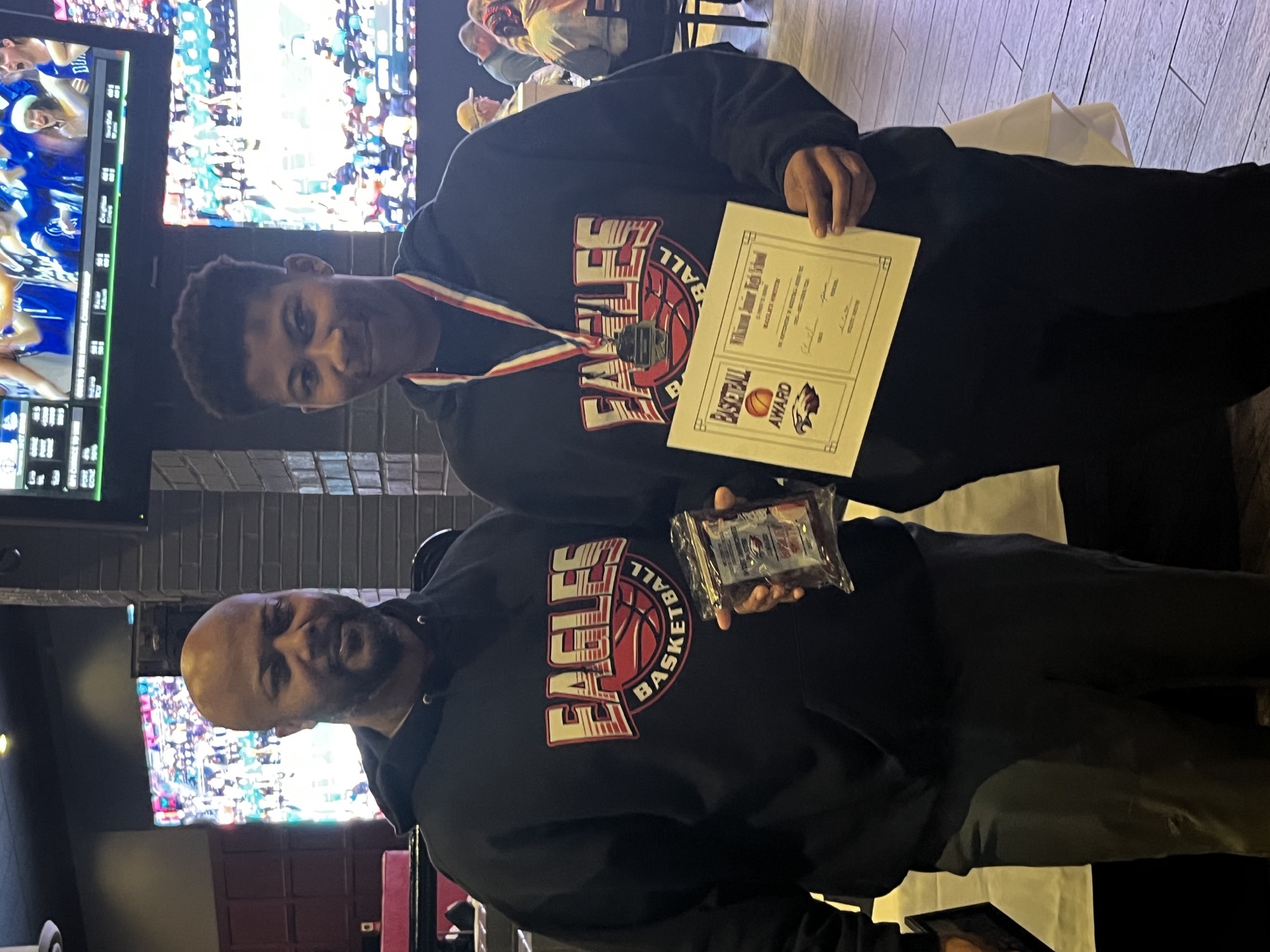 Coach and athlete celebrating an award