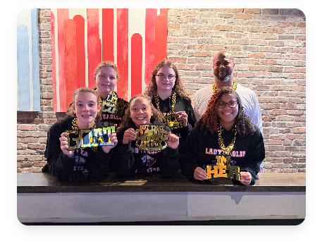 Young athletes with GOAT and DAWG signs